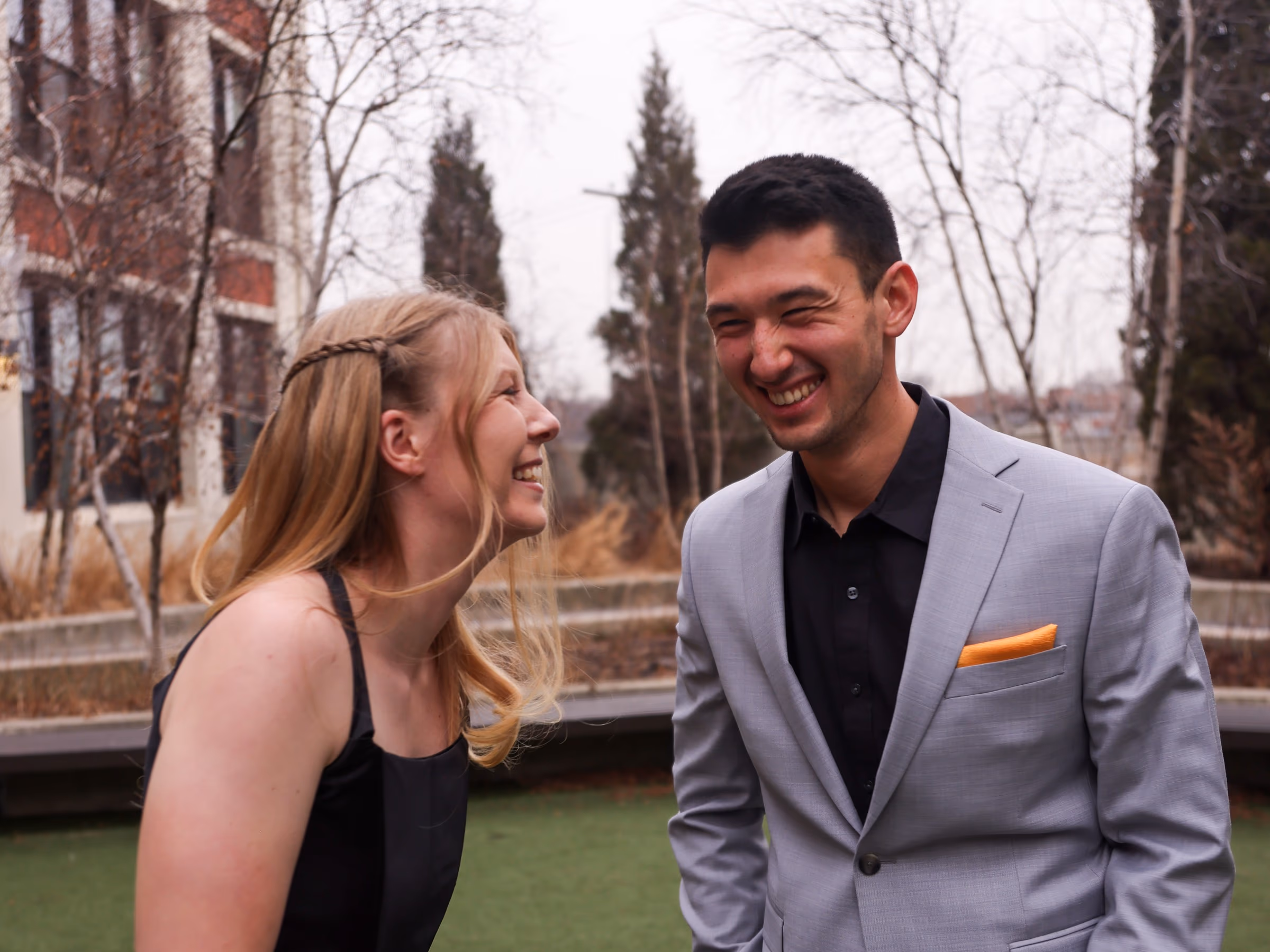 Couple laughing at each other on a rooftop in winter